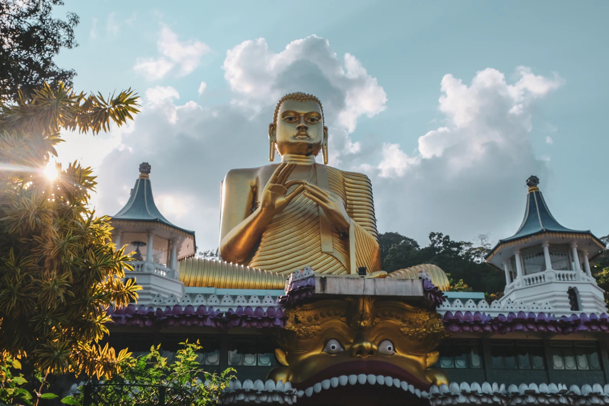 Het gouden Boeddhabeeld van Dambulla onder een wolkenlucht