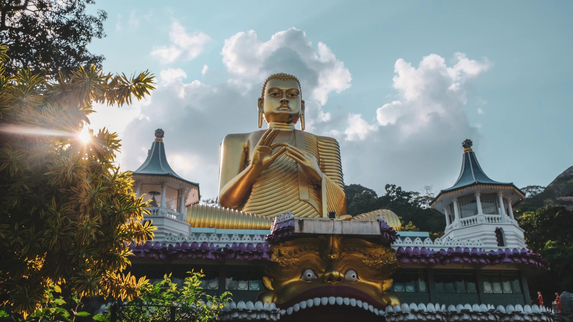 Het gouden Boeddhabeeld van Dambulla onder een wolkenlucht