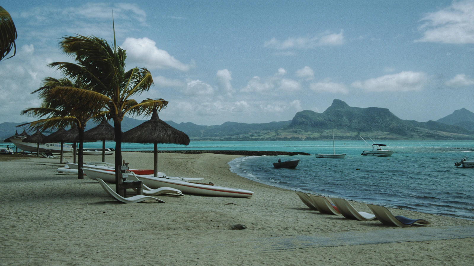 Strand met palmen en bootjes in de lagune van Mauritius