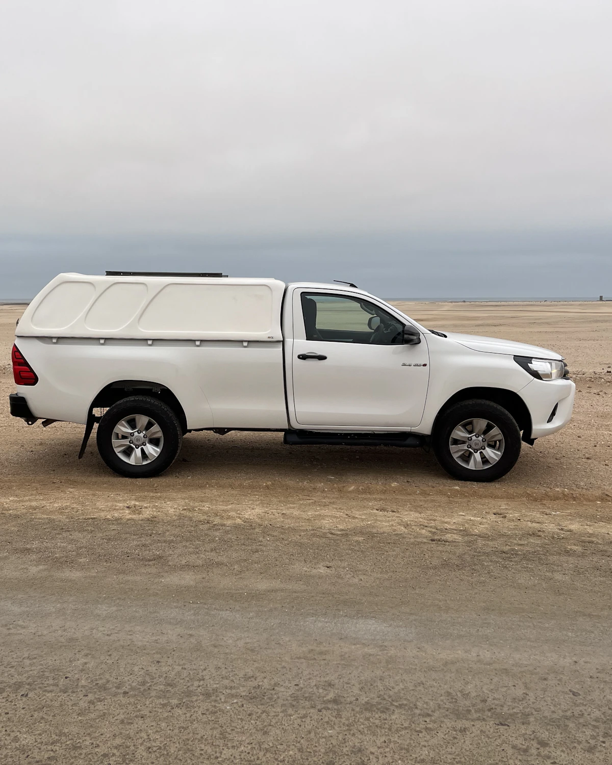 Witte pickup-truck in het woestijnlandschap van Namibië