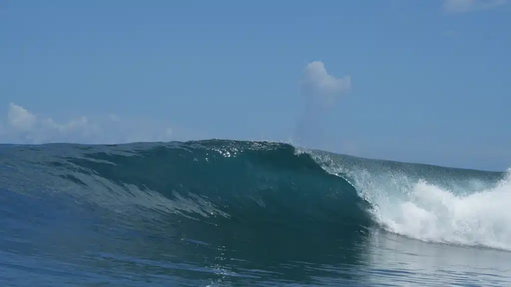 Brekende oceaangolf bij Thulusdhoo, populair surfeiland in de Malediven