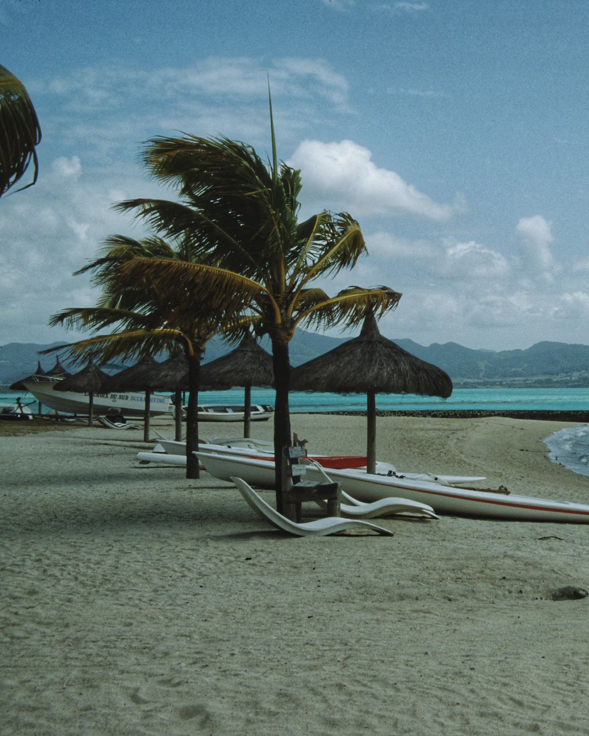 Strand met palmen en bootjes in de lagune van Mauritius