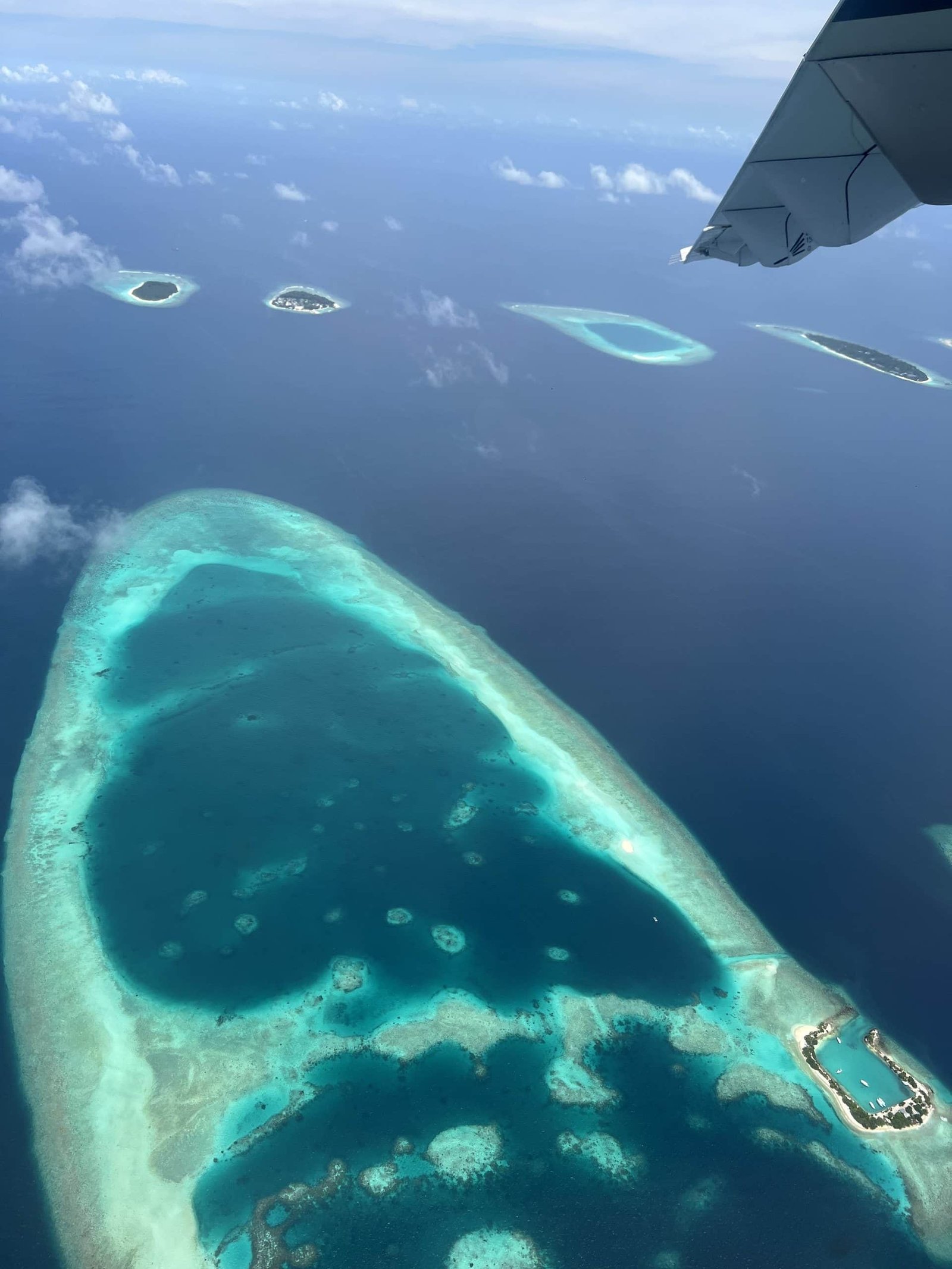 Luchtfoto van een atol met een rif en een turquoise lagune op de Malediven