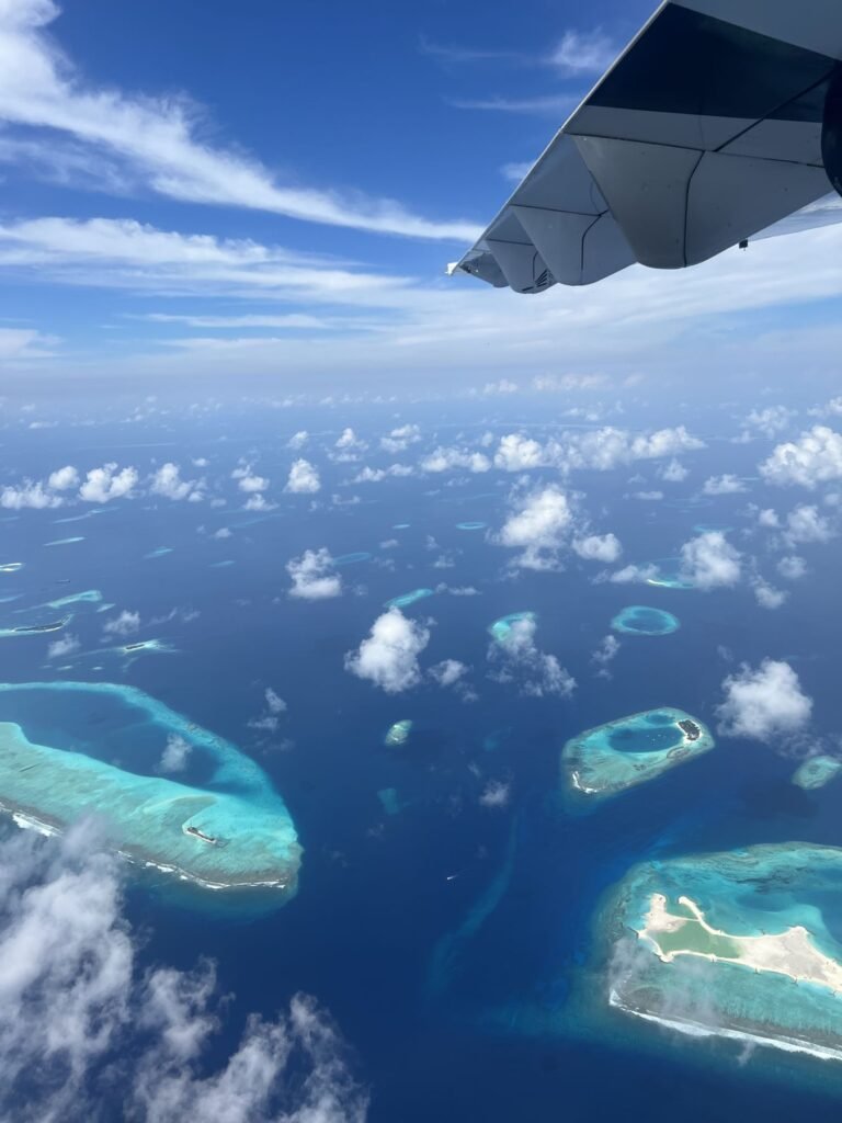 Atollen en lagunes vanuit het vliegtuig bij het opstijgen vanaf Malé