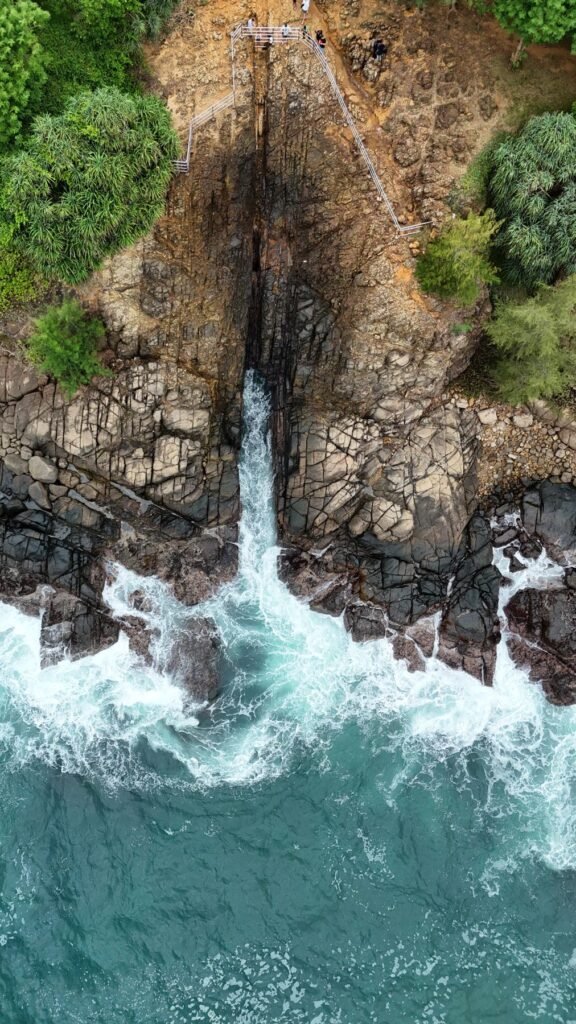 Luchtfoto van het blowhole bij Hiriketiya waar de golven tussen de rotsen omhoog spuiten