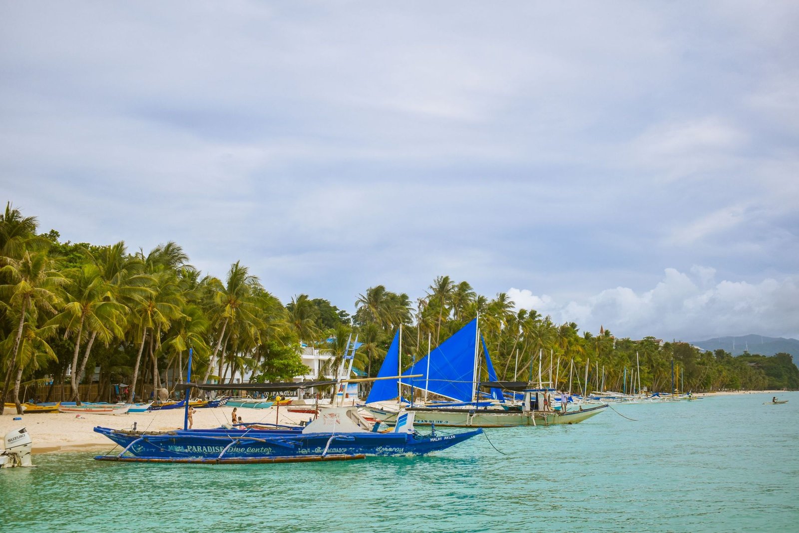 Zeilboten en palmbomen aan White Beach op Boracay