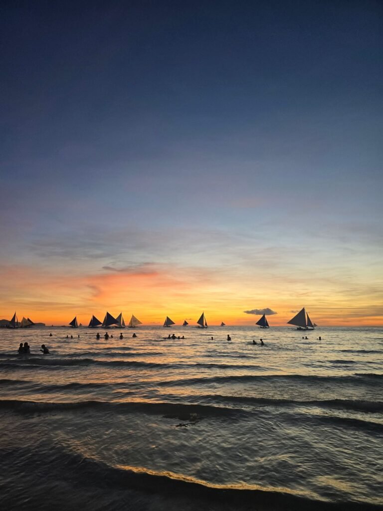Zeilboten bij zonsondergang voor White Beach op Boracay
