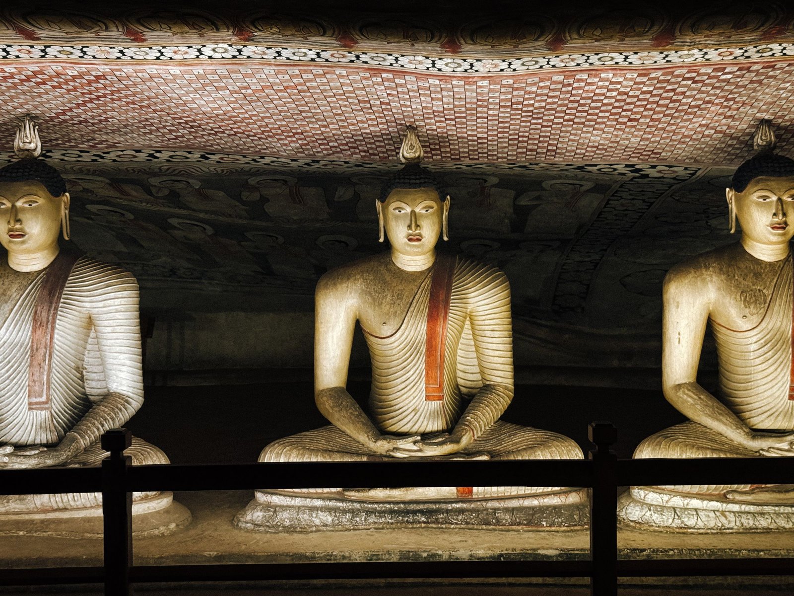 Rij Boeddhabeelden onder de rots in de grottempel van Dambulla