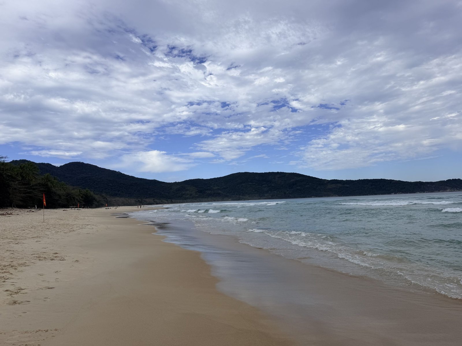 Lange baai met wit zand en groene heuvels op Ilha Grande