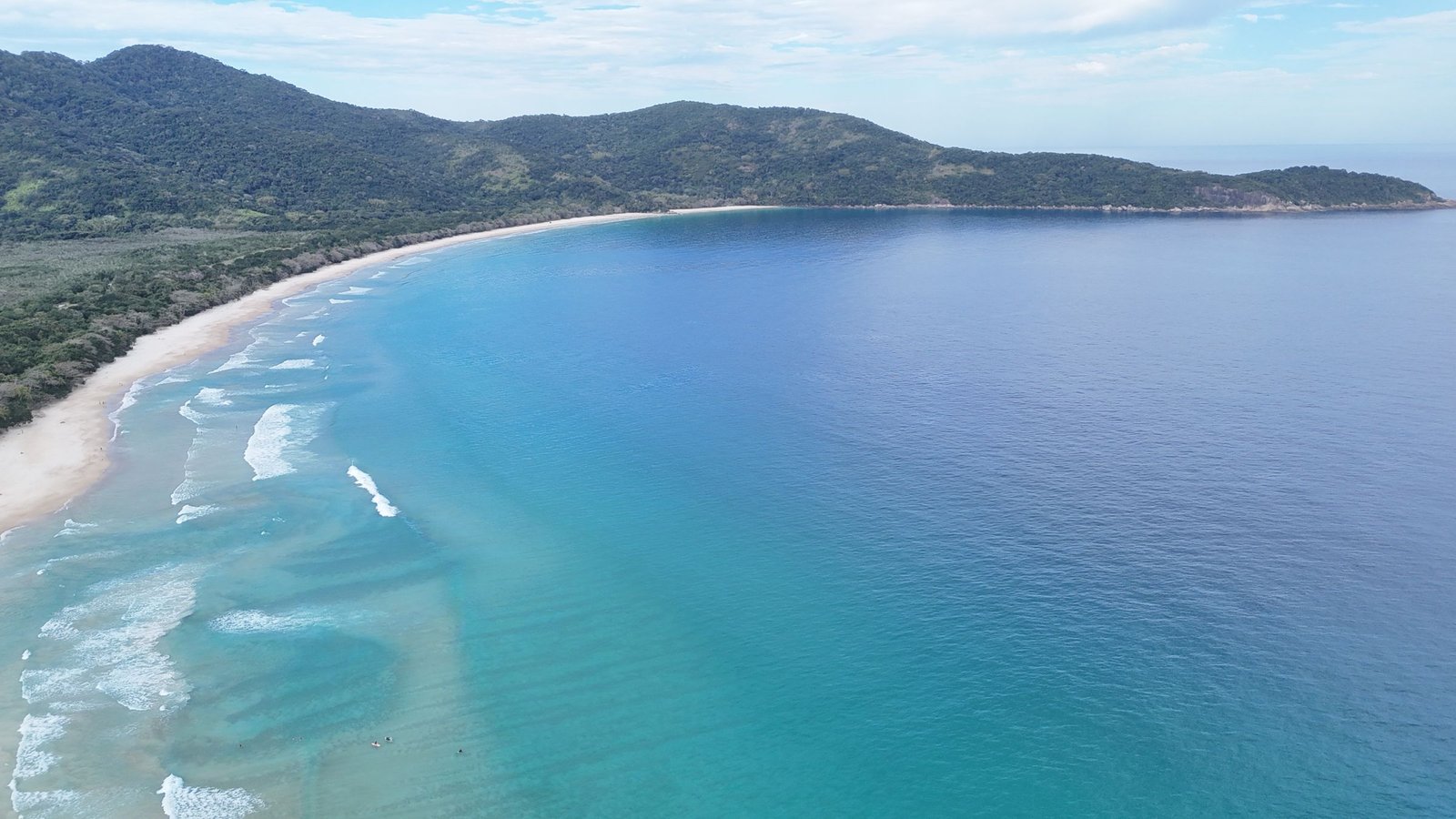 Luchtfoto van een lange baai met turquoise water en jungle op Ilha Grande