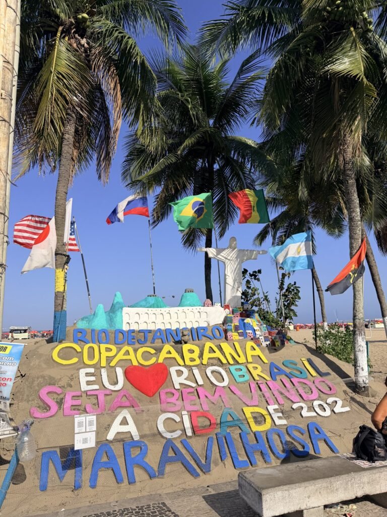 Zandsculptuur met Eu amo Rio op het strand van Copacabana