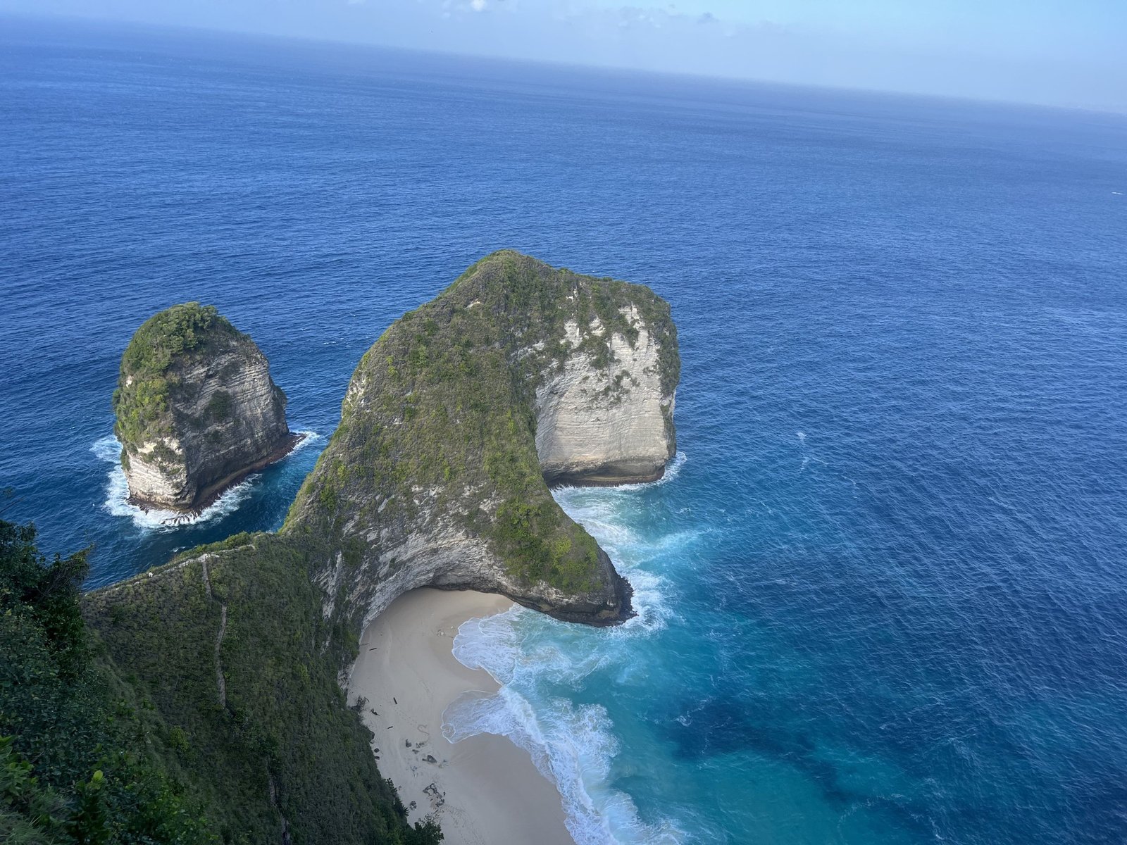 Uitzicht op Kelingking Beach op Nusa Penida met het steile pad over de rotsrug