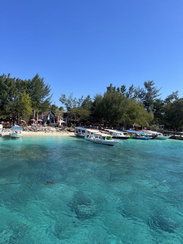 Turquoise water en houten boten bij de haven van Gili Trawangan