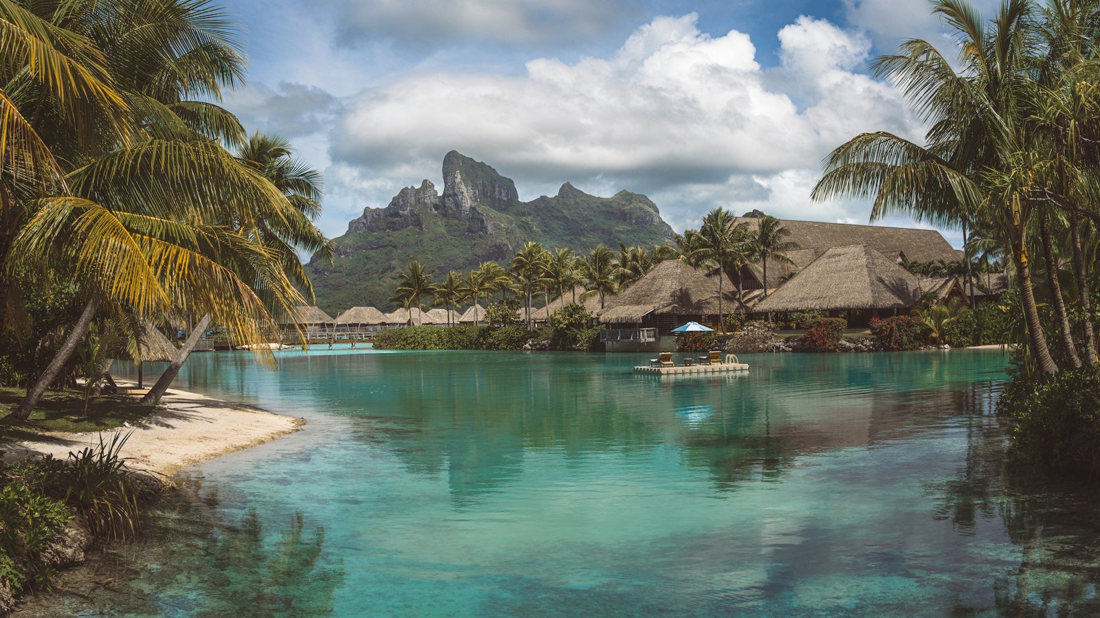 Lagune met boot en palmbomen bij Bora Bora in Frans-Polynesië