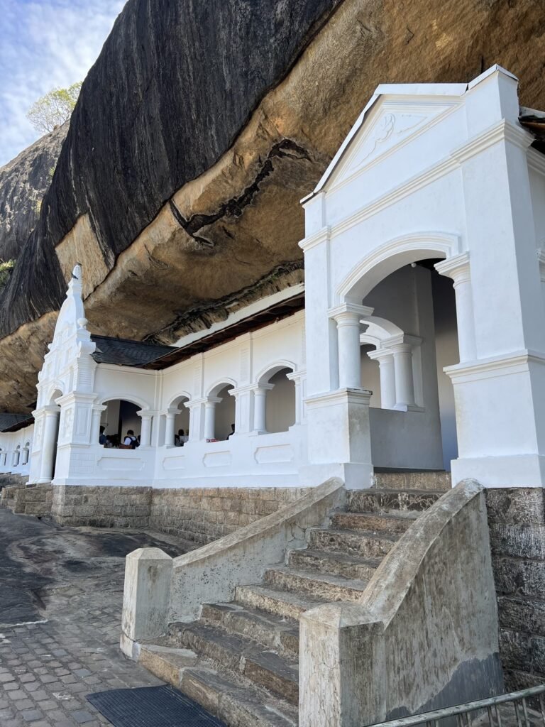 Witte ingang van de grottempel van Dambulla onder de overhangende rots
