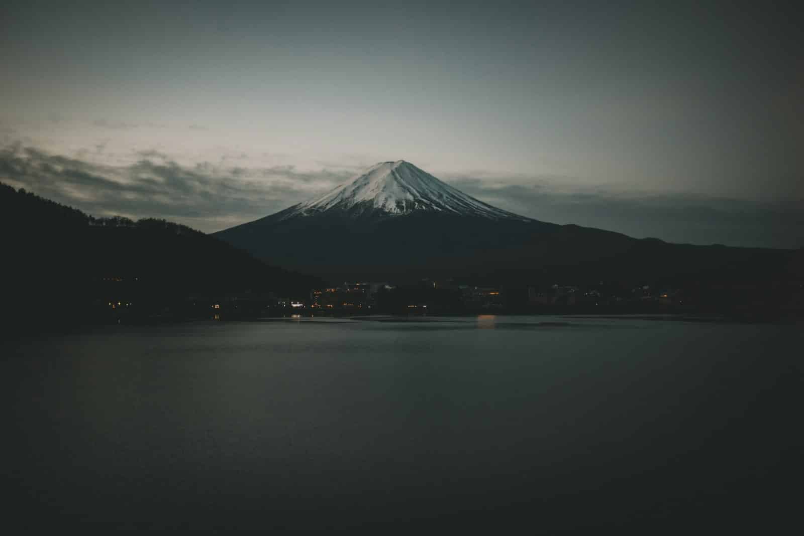 De berg Fuji die oprijst boven een donker meer in Japan