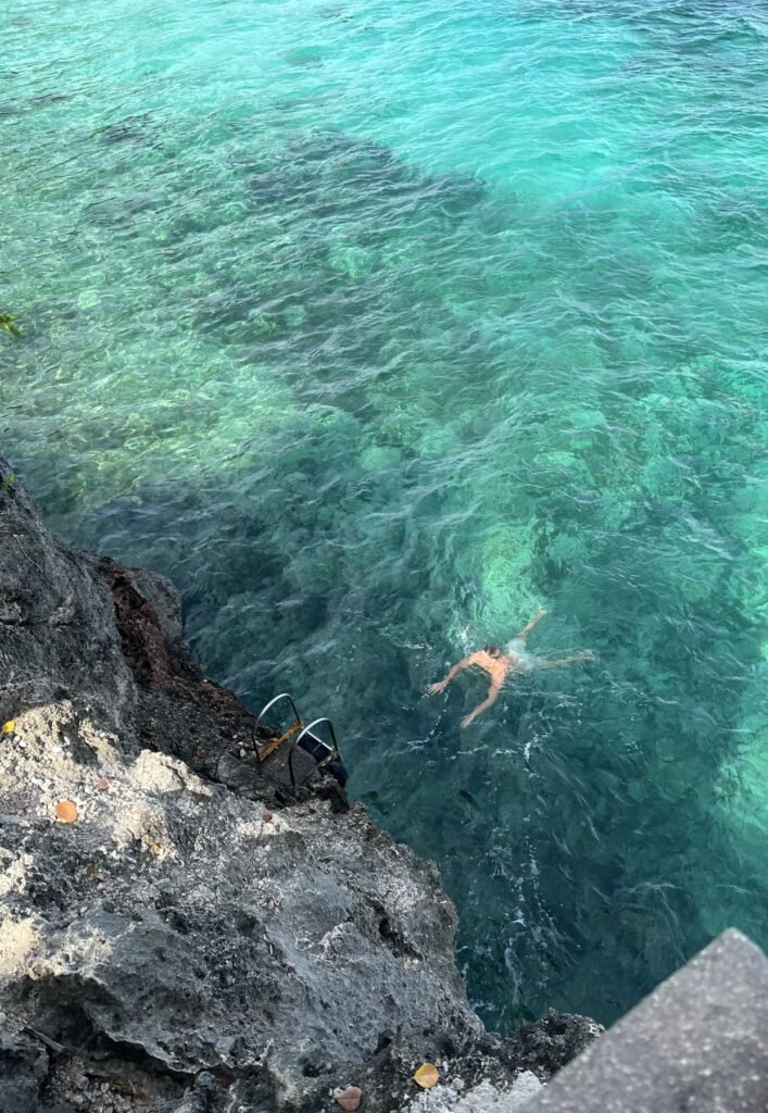 Zwemmer in helder water onder een klif op Siquijor