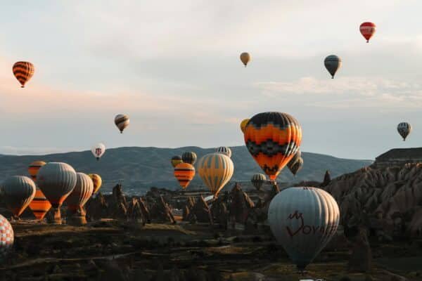 Tientallen luchtballonnen boven het rotslandschap van Cappadocië bij zonsopkomst
