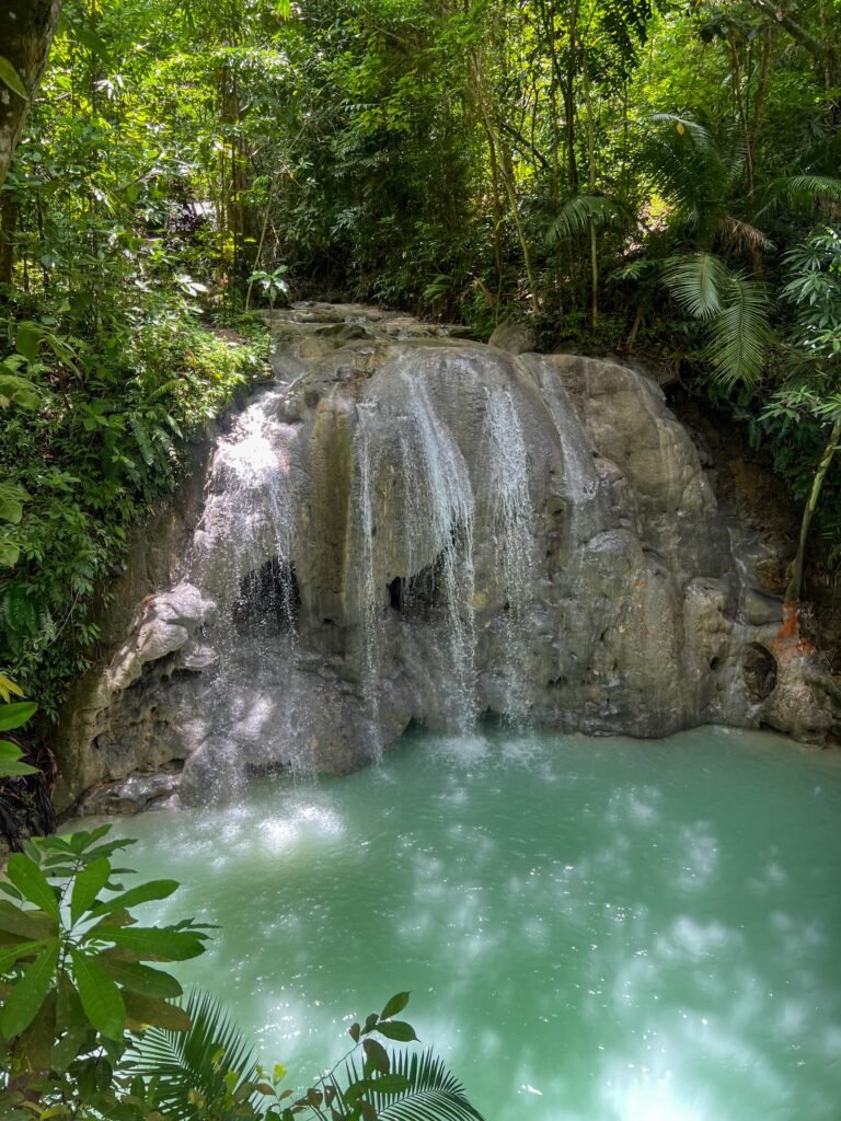 Waterval met turquoise poel in het bos bij Lugnason Falls op Siquijor