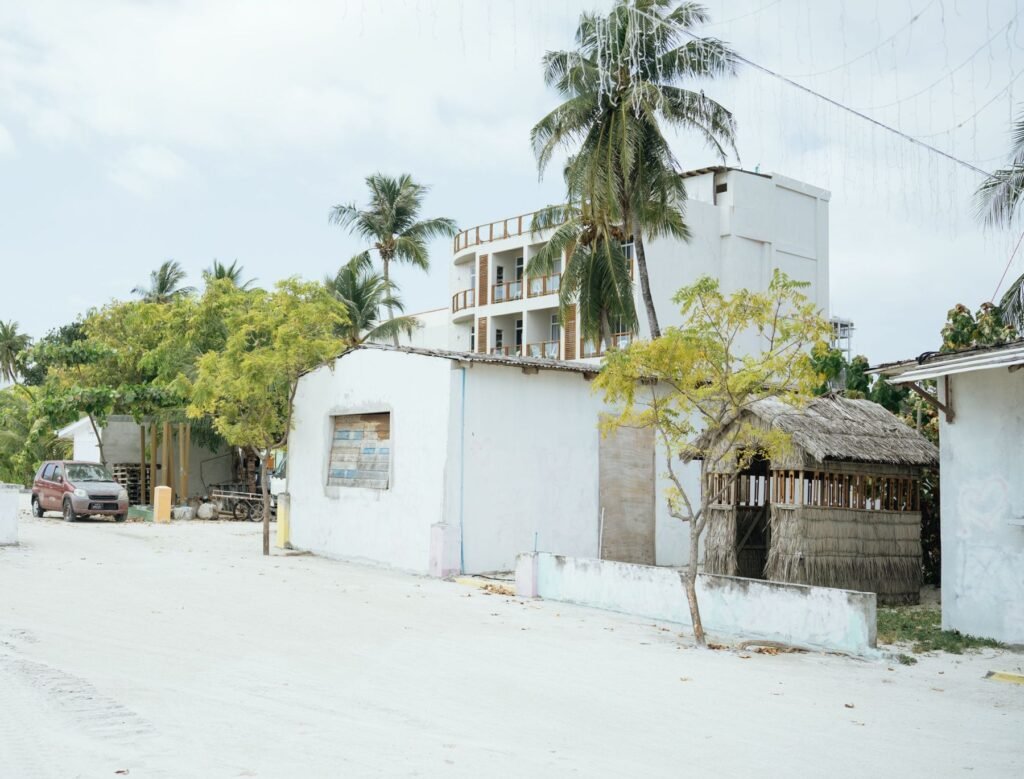 Zandweg met huizen en palmbomen in het dorp op Maafushi