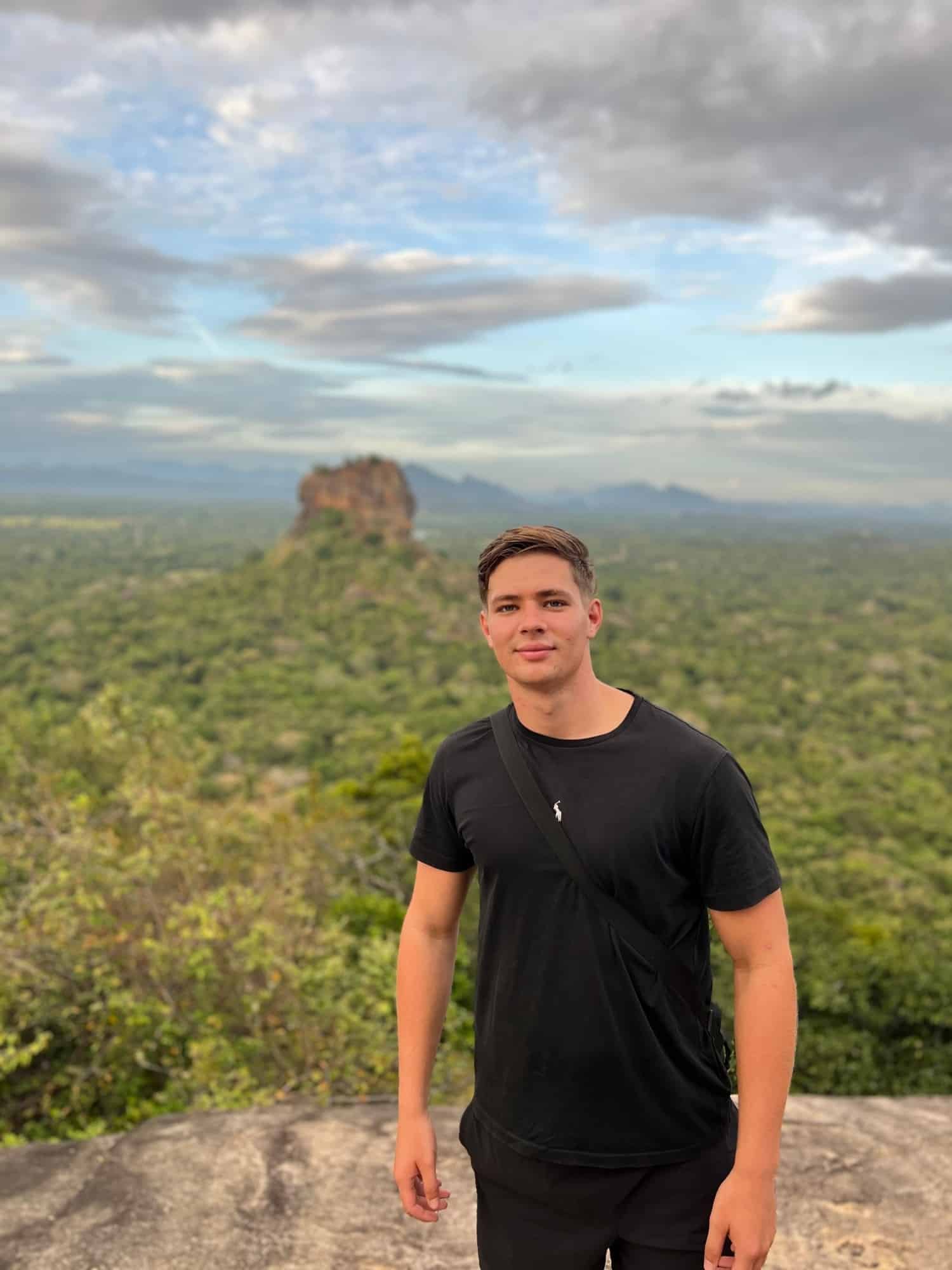 Mitchel op de rots van Pidurangala met de Leeuwenrots van Sigiriya op de achtergrond