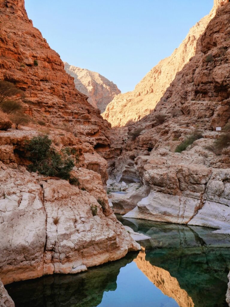 Zonovergoten kloof met een helder turquoise poel in een wadi in Oman