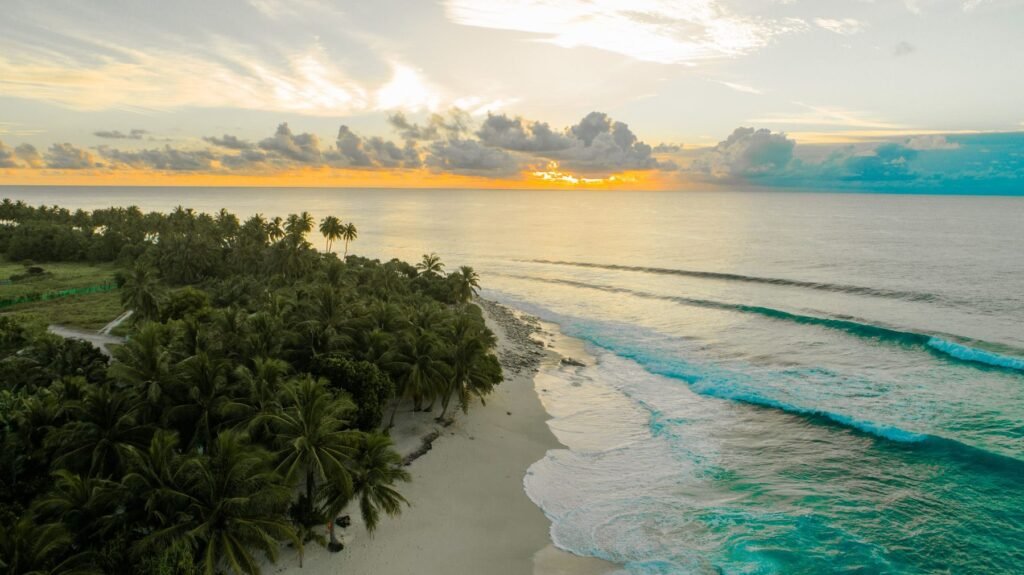 Palmbomen en strand van een Maledivisch eiland bij zonsondergang
