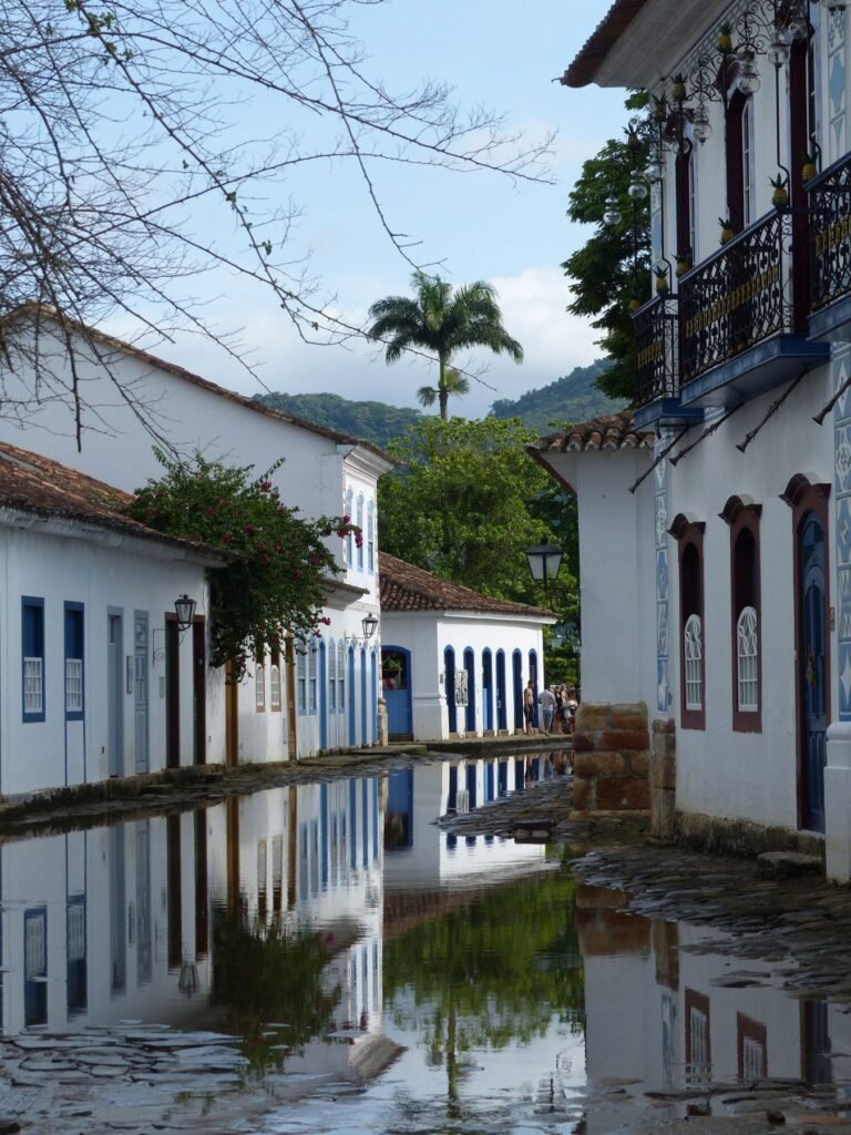 Ondergelopen keienstraat in Paraty bij springtij, met de gevels weerspiegeld in het water