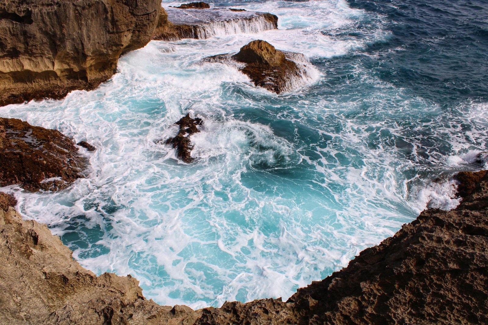 Golven slaan in de rotsbaai van Devil’s Tear op Nusa Lembongan