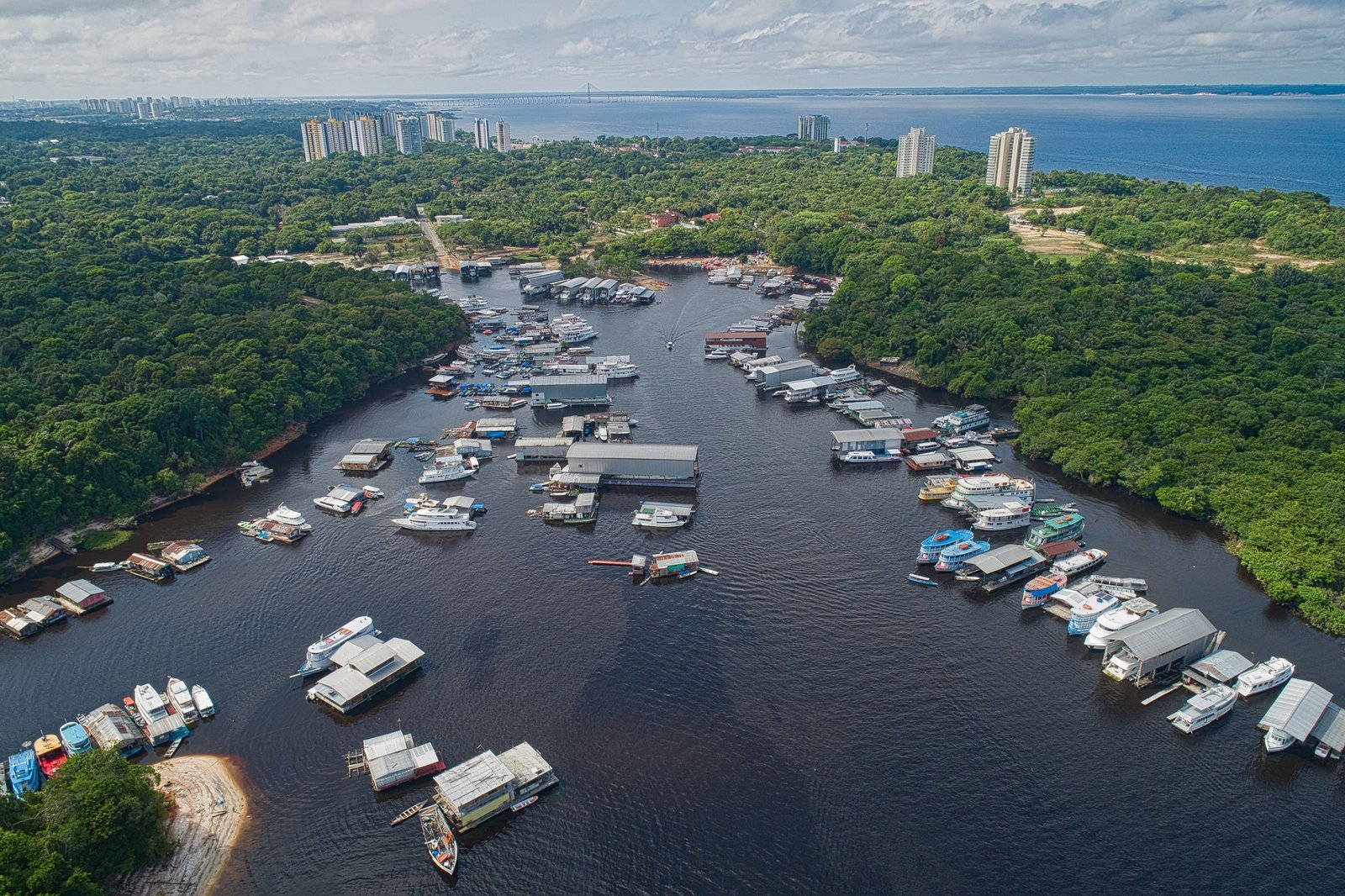 Drijvende huizen en boten aan de waterkant van Manaus