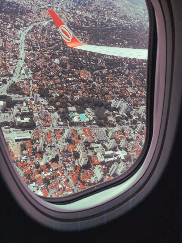 Uitzicht door een vliegtuigraampje op een Braziliaanse stad