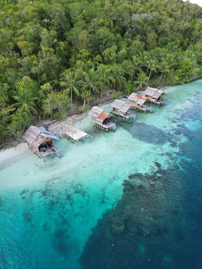 Luchtfoto van bungalows aan het water op de Togean-eilanden