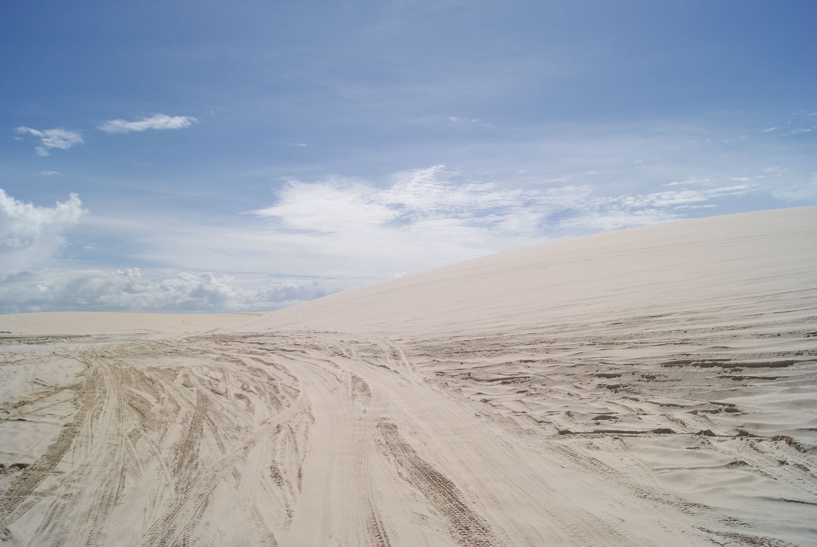 Uitgestrekte witte duinen met bandensporen bij Jericoacoara