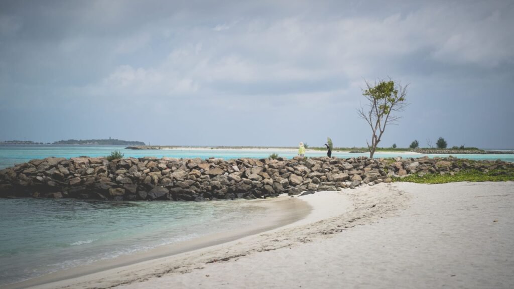 Wit strand en golfbreker bij het lokale eiland Maafushi