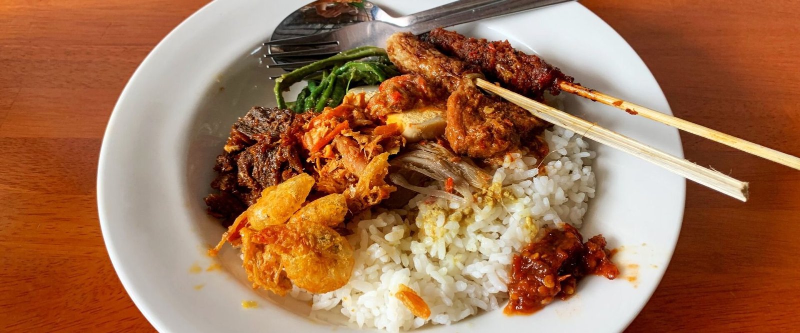 Bord nasi campur met saté en rijst