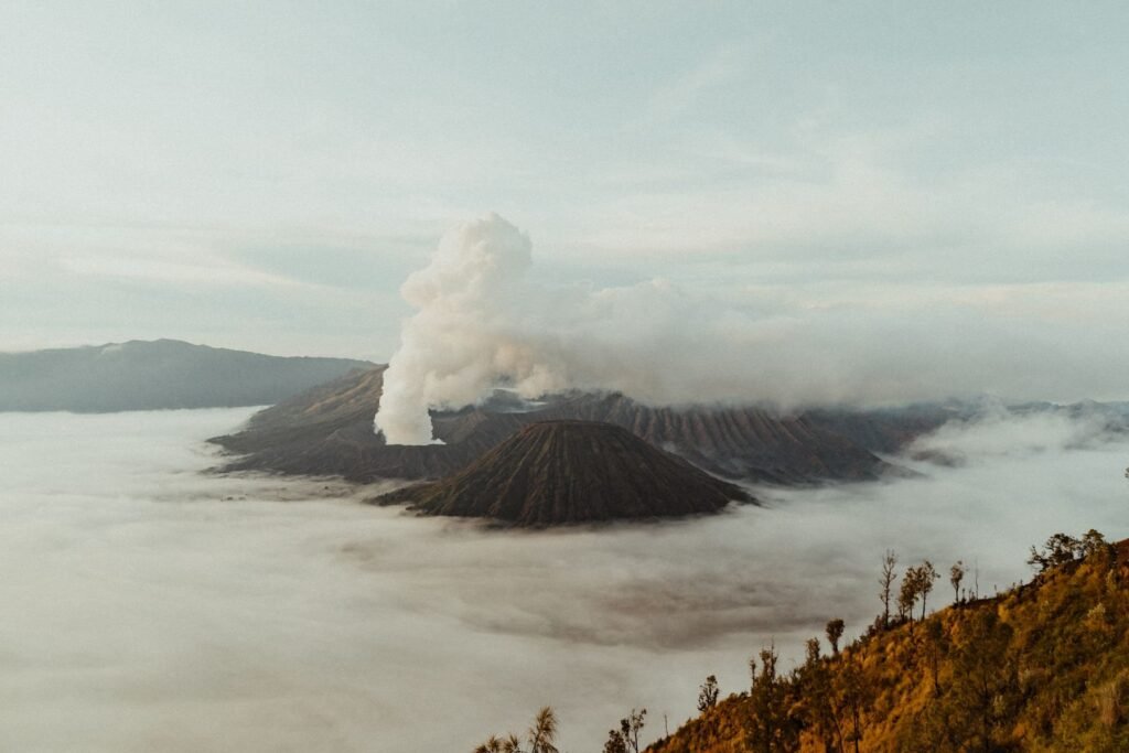 Rookpluim boven de Bromo in een zee van wolken
