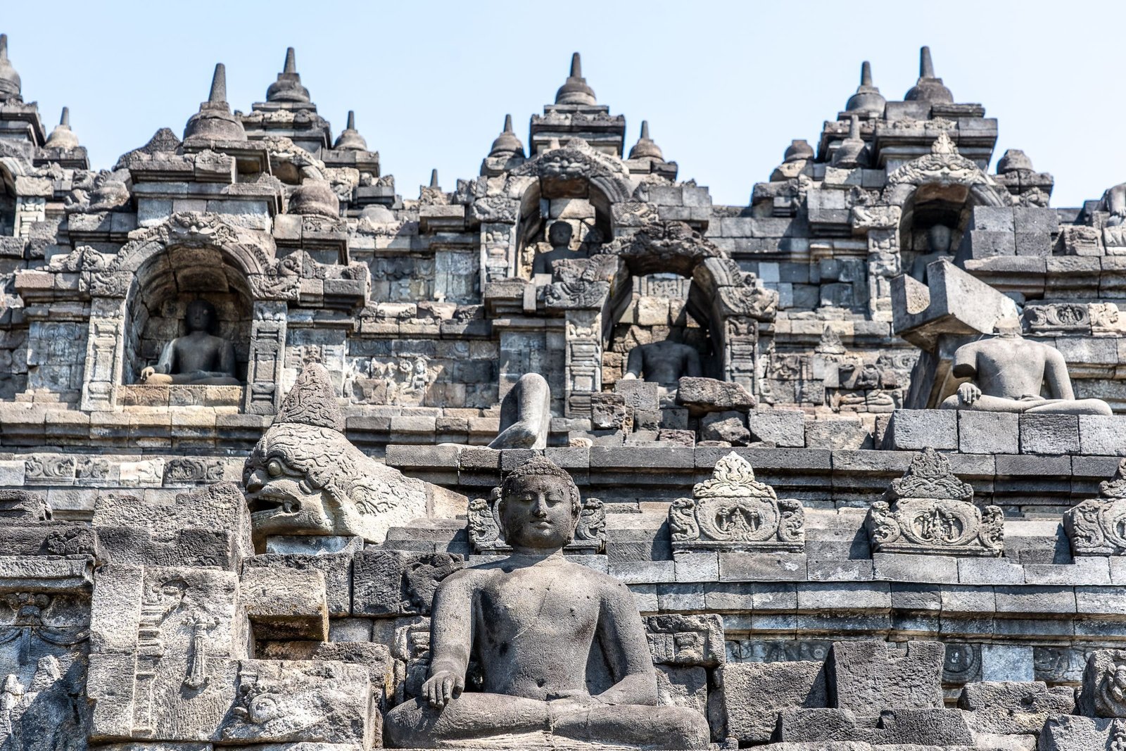 Stenen reliëfs en een boeddhabeeld op de Borobudur