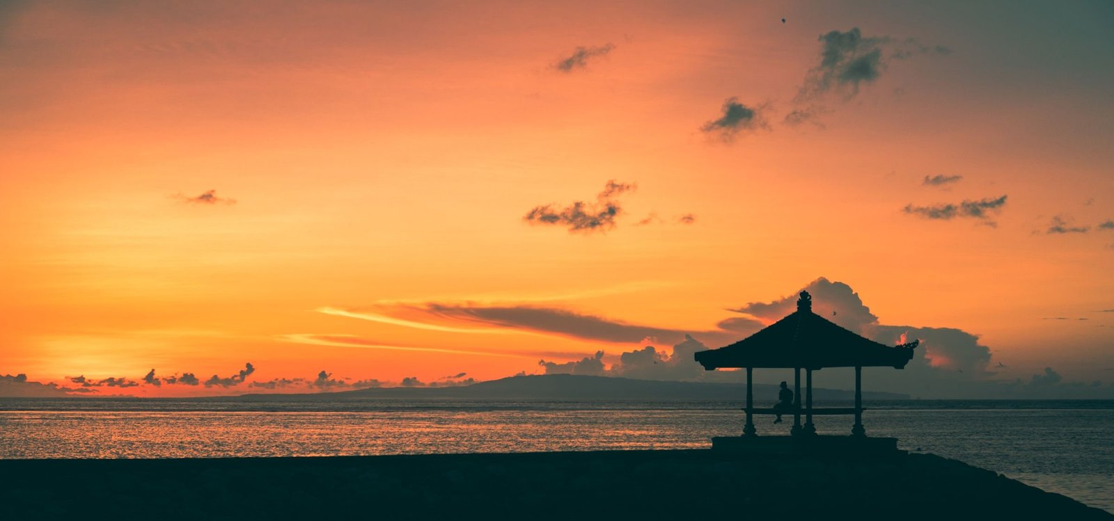 Silhouet van een balé bij zonsopkomst op het strand van Sanur