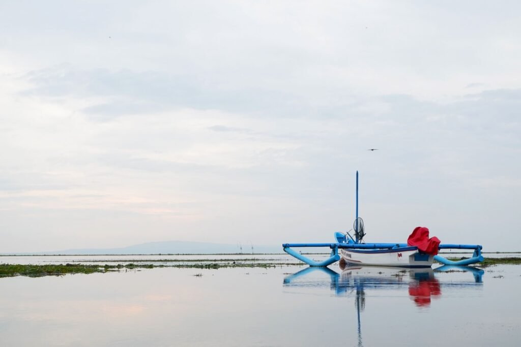 Traditionele jukung-boot op stil water bij Lovina