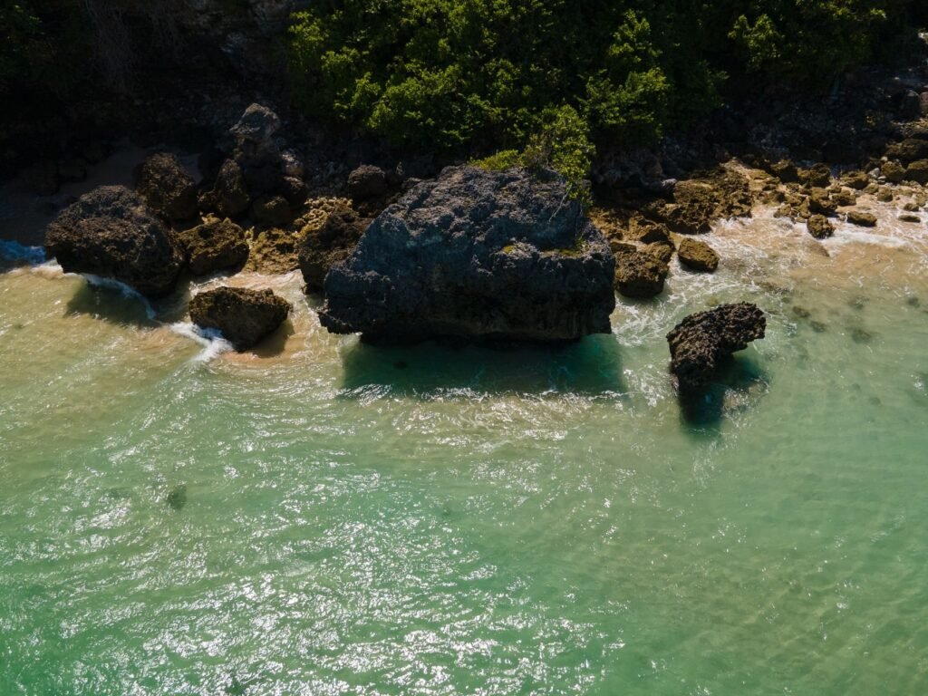 Rotsen en helder water aan een strand op het Bukit-schiereiland van Bali