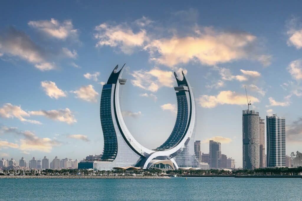 De sikkelvormige Katara Towers boven de kustlijn van Doha in Qatar
