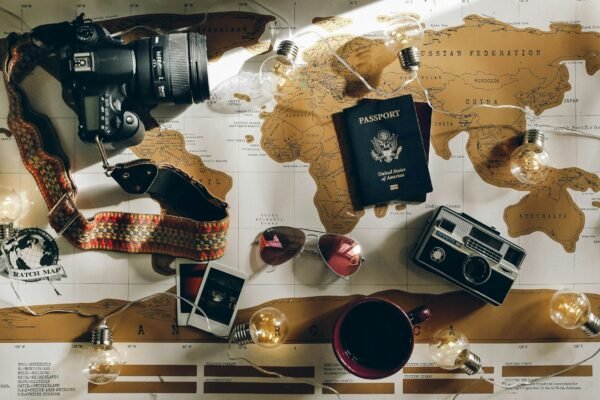 Wereldkaart met paspoort, camera en zonnebril uitgestald om een reis te plannen