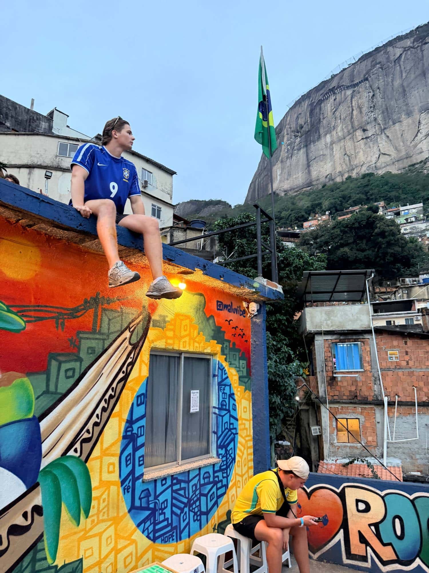 Mitchel in een Braziliaans voetbalshirt op een dak in de favela Rocinha in Rio de Janeiro