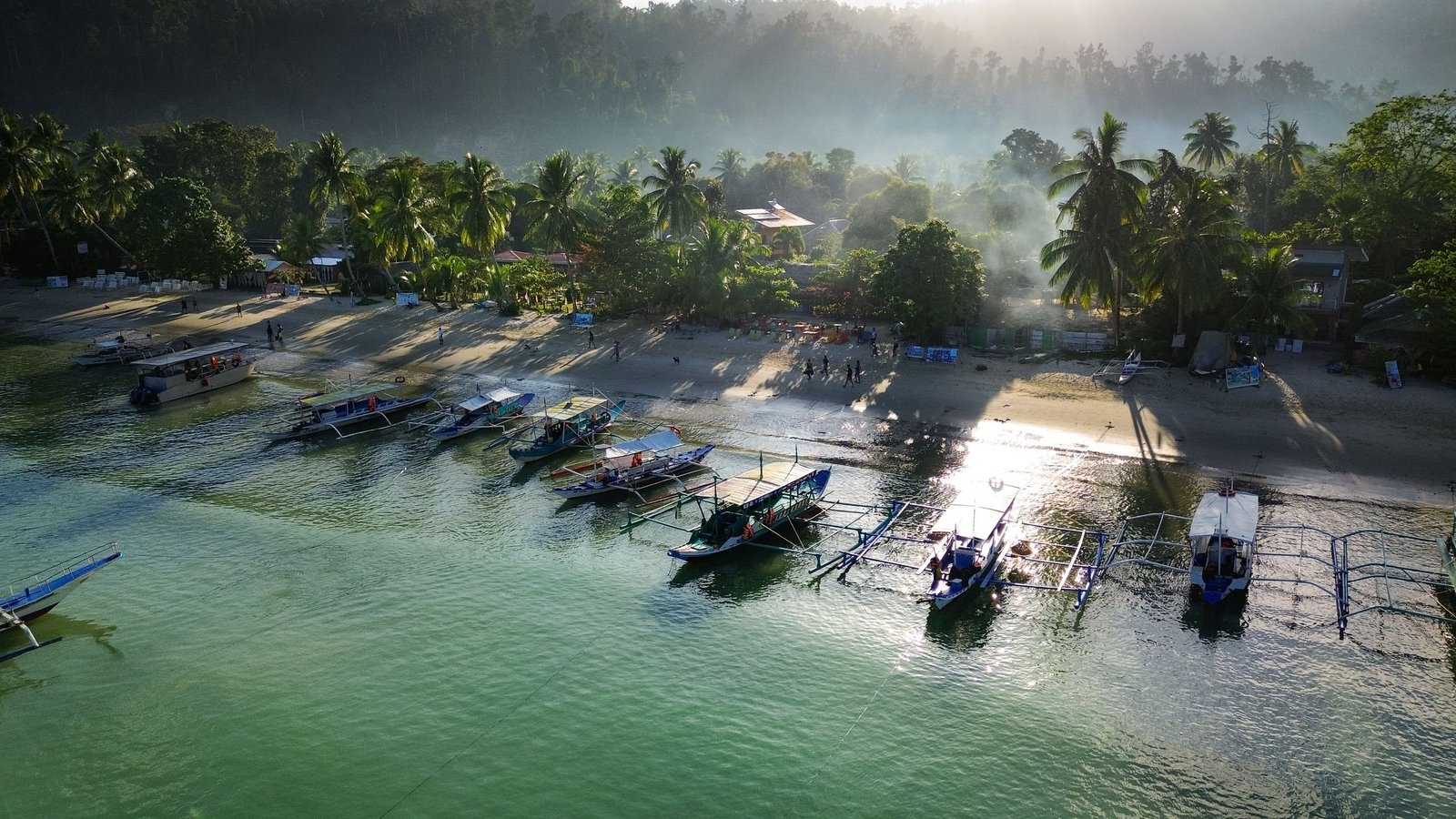 Luchtfoto van bangka’s voor het strand van San Vicente op Palawan, waar Port Barton ligt