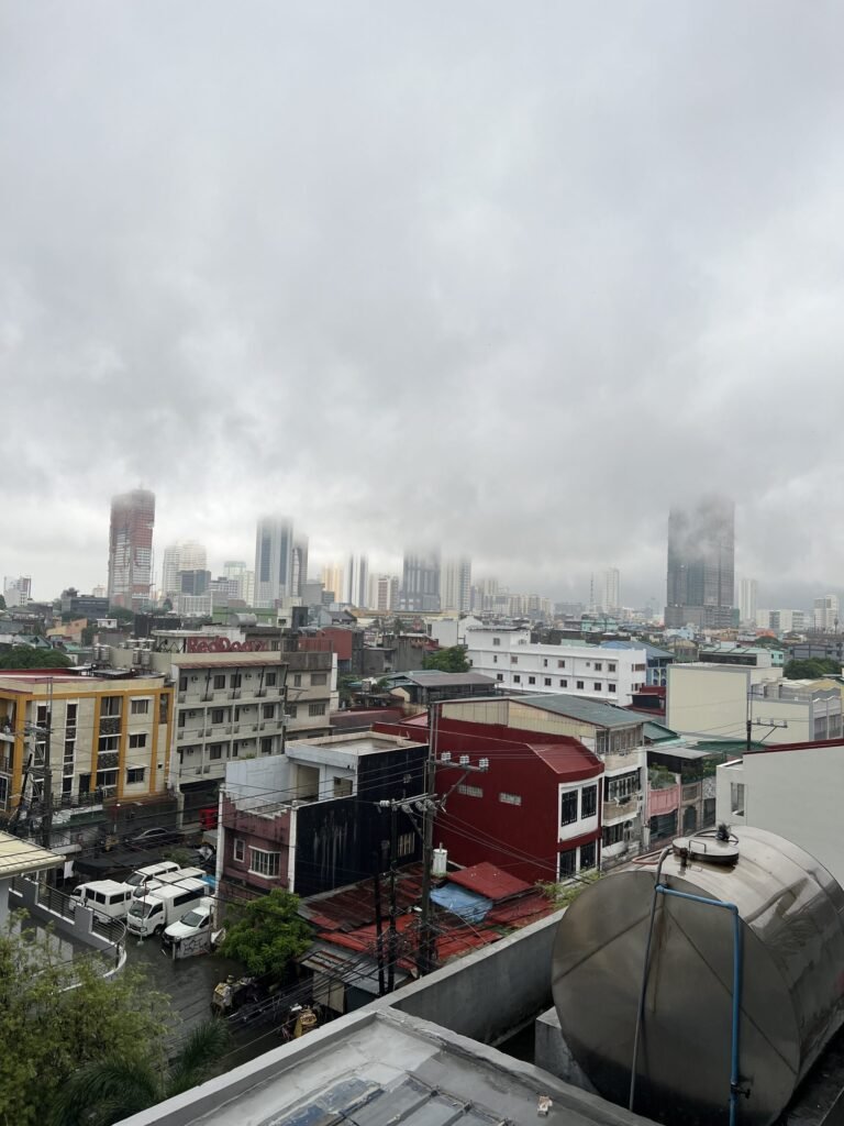 Uitzicht over de daken en wolkenkrabbers van Manila op een regenachtige dag