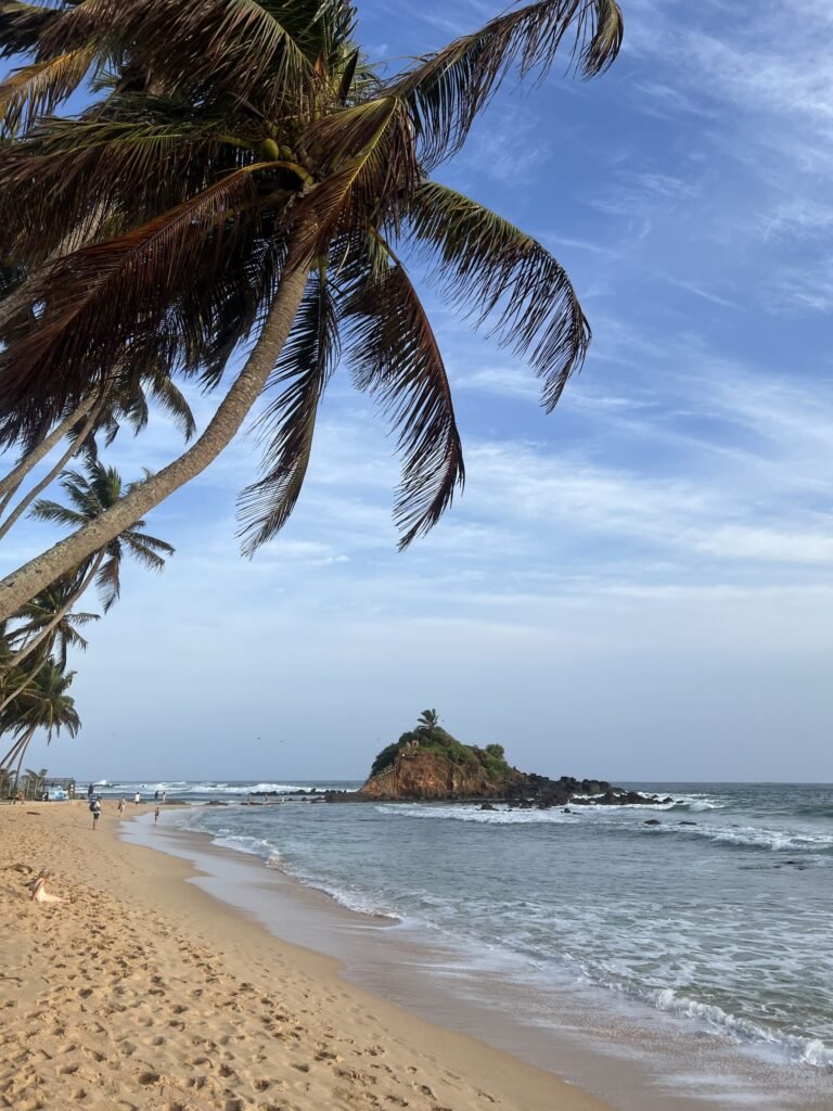 Strand van Mirissa met Parrot Rock in de baai