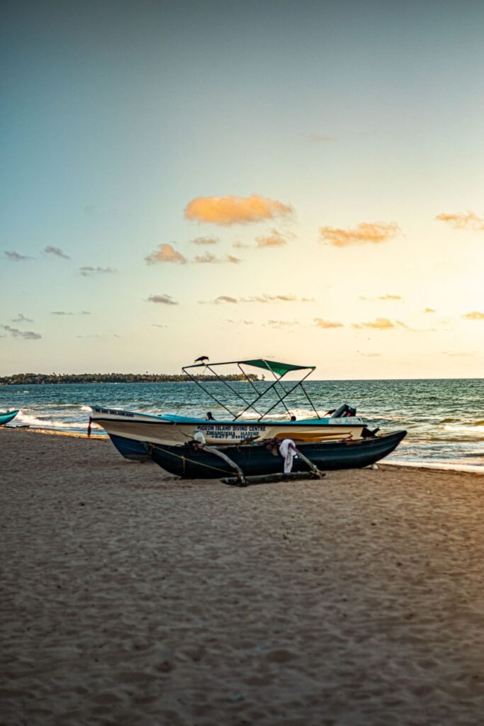 Vissersboot op het strand van Trincomalee bij zonsondergang