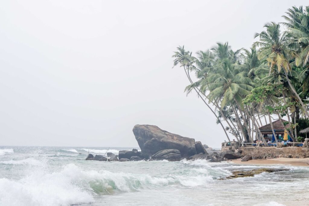 Strand van Unawatuna met rotsen, golven en palmbomen