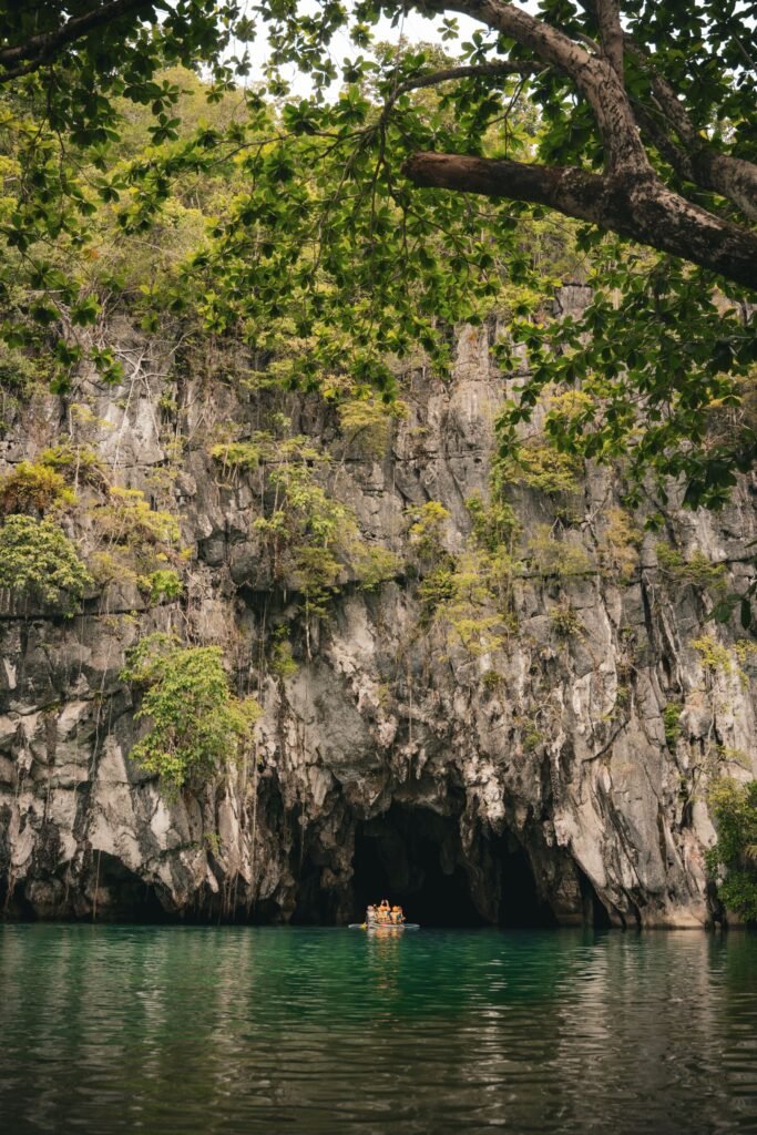Bootje bij de grotingang van de Underground River onder een kalkrots bij Puerto Princesa