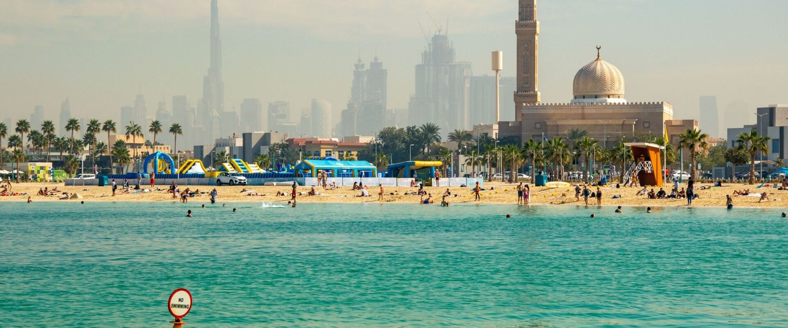 Strand met moskee en skyline in Dubai